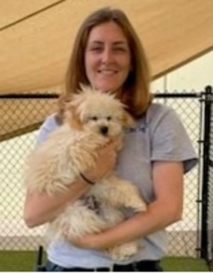 Scarlett, trainer at Elite Suites, holding a dog